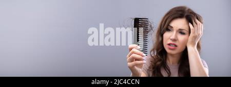 Close-up Of A Worried Woman Holding Comb Suffering From Hairloss Stock Photo