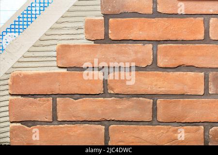 Consistent structure of the design of the facade of the building with external decorative brick tiles. Stock Photo