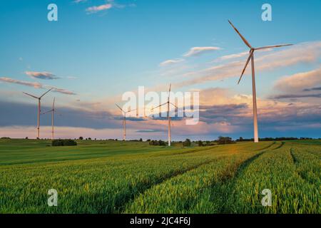 Wind turbines on the background of a dramatic evening sky Stock Photo