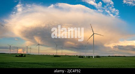 Wind turbines on the background of a dramatic evening sky Stock Photo