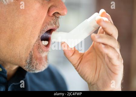 Close-up Of A Man Using Asthma Inhaler Stock Photo