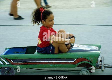 Cuban little girl driving a nostalgic toy car, festival in St. Lucia, Cuba, Caribbean Stock Photo