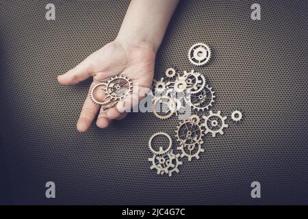 Hand holding gear wheels as the concept of mechanism Stock Photo