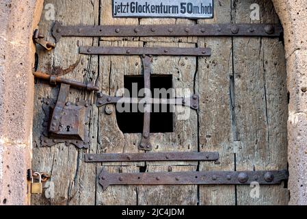 Rusty lap, bolts, bars and fittings, weathered wooden door, entrance to historic dungeon, dungeon, medieval prison in the town tower, Old Town, Lich Stock Photo