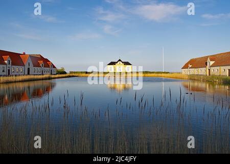 Parts of a castle and estates reflected in a calm pond, Valdemars Slot, Tasinge, Denmark Stock Photo