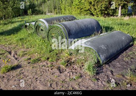 Rolls of old artificial grass outdoors Stock Photo