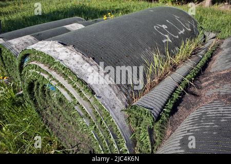 Rolls of old artificial grass outdoors Stock Photo