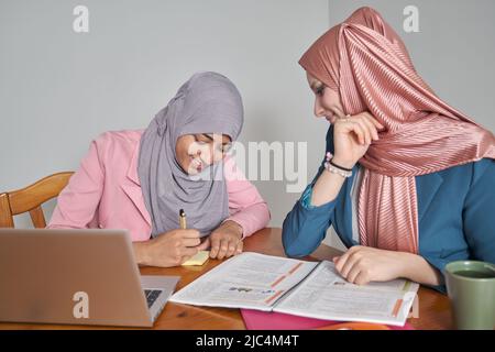 Two muslim female university students wearing hijab studying after class. Stock Photo