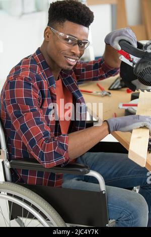 disabled worker in wheelchair in a carpenters workshop Stock Photo