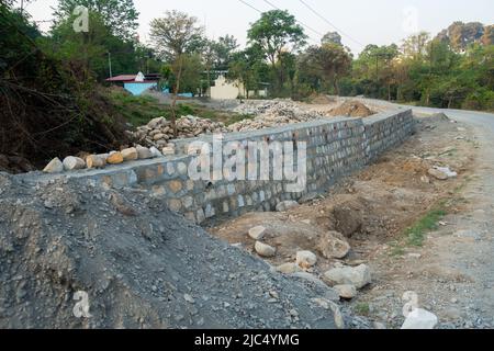 A pile of stone alongside road for constructing a stone retaining wall to prevent landslide and cutting. Uttarakhand India. Stock Photo