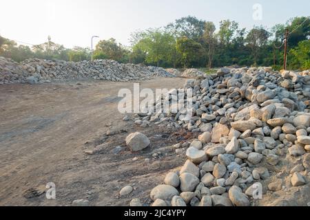 A pile of stone alongside road for constructing a stone retaining wall to prevent landslide and cutting. Uttarakhand India. Stock Photo
