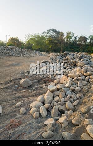 A pile of stone alongside road for constructing a stone retaining wall to prevent landslide and cutting. Uttarakhand India. Stock Photo