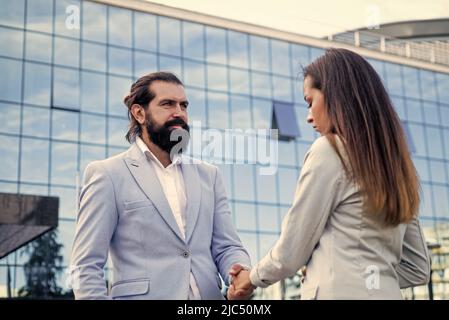 business couple shaking hands. bearded man meet woman outdoor. business meeting. Stock Photo