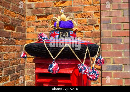 Yarn bombing, royal mail post box, crown, queens platinum jubilee weekend, hamstreet, kent, uk Stock Photo