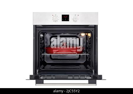Electric oven with open door, illuminated and red baking dish. Front view. Isolated on white Stock Photo
