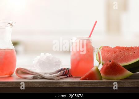 Watermelon slush with sliced fruit and crushed ice in a bowl on wooden table in a kitchen. Front view. Horizontal composition. Stock Photo