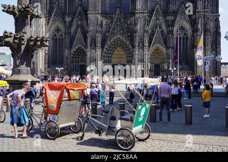 Numerous tourists stand in front of the Cologne Cathedral and marvel at the Cathedral Church of Saint Peter. Cologne, North Rhine-Westphalia, Germany, Stock Photo