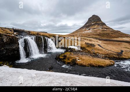 Picturesque landscape scenery with Kirkjufell mountain (463 m) and Kirkjufellsfoss waterfall in late winter, Snæfellsnes, near Grundarfjörður, Iceland Stock Photo