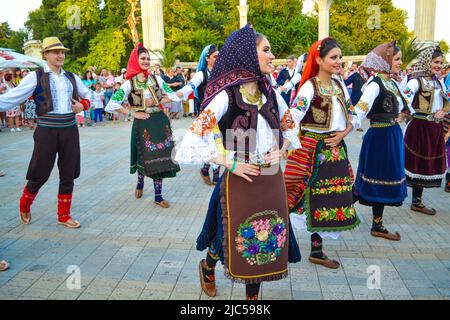 Serbian dancers dressed in traditional costumes performing at street procession of 23th International Folklore Festival,Varna Bulgaria 2014 Stock Photo