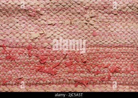 Rag rug close up. Recycled fabric. Pink, white weaved texture Traditional recycled scandinavian carpet. Background. Wallpaper Stock Photo