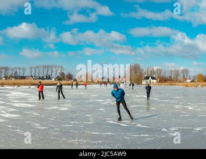 Scating on a frozen canal *** Local Caption ***  Netherlands,landscape, water, winter, snow, ice, people, scaters,  ,Westzaan,   Noord-Holland , Nethe Stock Photo