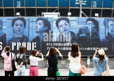 June 10, 2022, Tokyo Japan: People take photos of a giant billboard of the South Korean boy band BTS (Bangtan Boys) announcing their new album Proof outside Shibuya Station. Their album Proof and its title track Yet To Come were released on June 10. (Credit Image: © Rodrigo Reyes Marin/ZUMA Press Wire) Stock Photo