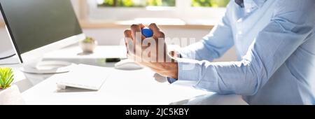 Close-up Of Businessman Holding Stress Ball In Hand Stock Photo
