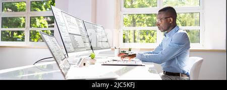 Computer programmer writing program code on computer in office Stock Photo