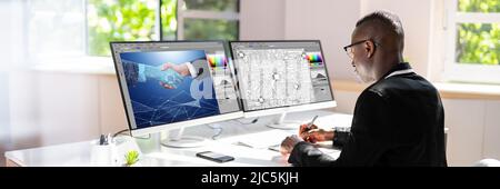 Young Male Designer Editing Photos On Computer In Office Stock Photo
