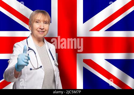 UK smiling mature doctor with stethoscope on flag of United Kingdom background Stock Photo