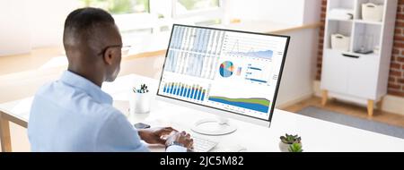 Close-up Of A Businessman's Hand Analyzing Graph On Computer At Workplace Stock Photo