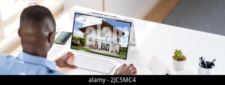 Man Selecting New House On Laptop At Home Stock Photo