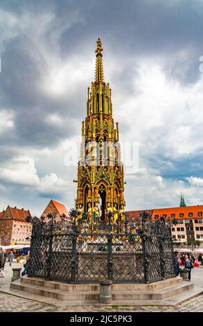 Nice full view of the Schöner Brunnen (beautiful fountain), a 14th-century fountain on Nuremberg's main market square. The tall stone pyramid rises... Stock Photo