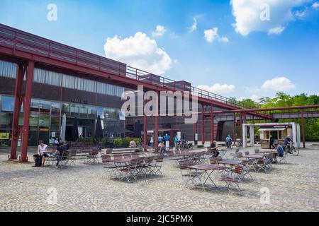 People sitting at the tables of the cafe in Zollverein in Essen, Germany Stock Photo