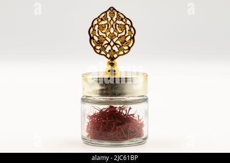 Packaged Iranian saffron in glass bottle on white background. close up Stock Photo