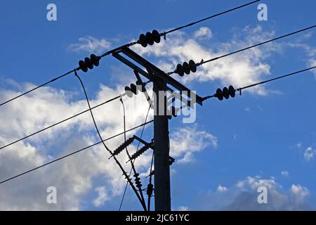 Rural three phase electrical power lines distribution, with insulators against a blue cloudy sky, Cheshire, England, UK, WA4 Stock Photo