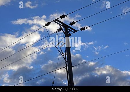 Rural three phase electrical power lines distribution, with insulators against a blue cloudy sky, Cheshire, England, UK, WA4 Stock Photo