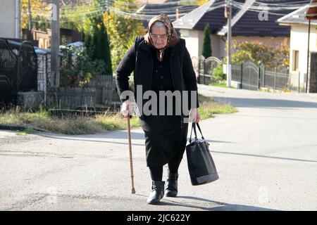 A widow walking on the village lane in Romania's countryside Stock Photo