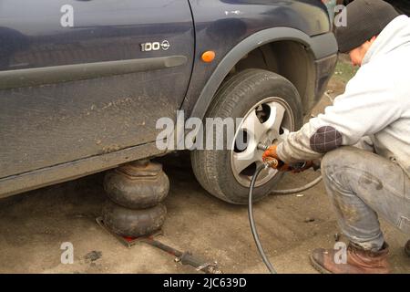 Mechanic removing the lug nuts from the tires of a vehicle Stock Photo