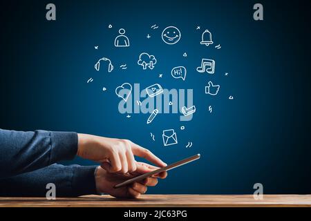 Blogging concept. Creating content for viewers on social networks. Hand with tablet with icons Stock Photo