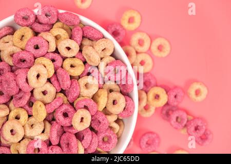 Quick cereal breakfast in the form of rings on a plate on a pink background Stock Photo