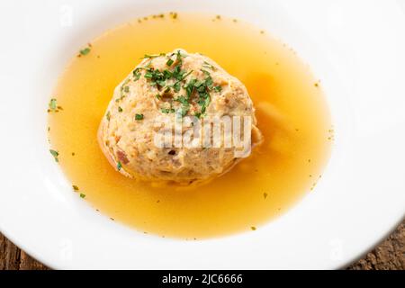 single speckknoedel in soup on wood Stock Photo