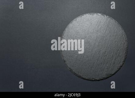 Round black slate dish plate top view empty copy space background. Stock Photo