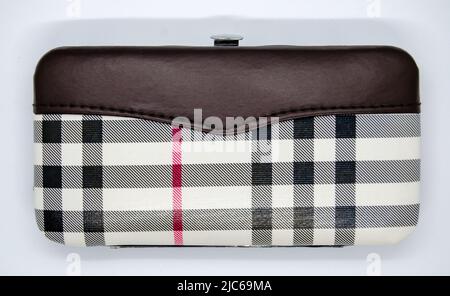 Women purse with tartan pattern, top view, isolated on white background. Female wallet with black, white and red color tartan design. Stock Photo