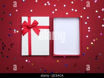 Empty opened gift box on red background,product advertisement display.Top view christmas design empty present box. Valentine's day object. Stock Photo