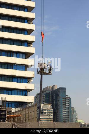 Workers concreting the skyscraper by crane on high rise, builder worker control concrete bucket on crane for concrete casting formwork, work security Stock Photo