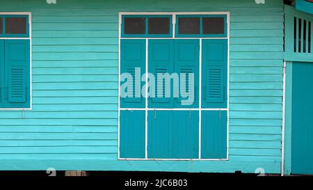 antique Green wooden windows on light green wooden wall. Stock Photo