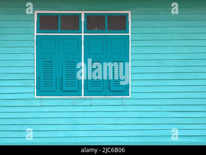 antique Green wooden windows on light green wooden wall. Stock Photo