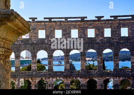 The historical amphitheater of Pula, Croatia in front of the Adriatic Sea with a marina Stock Photo
