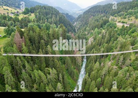 Top drone aerial view on a suspension bridge and a river valley in Swiss Alps forest, Switzerland Stock Photo